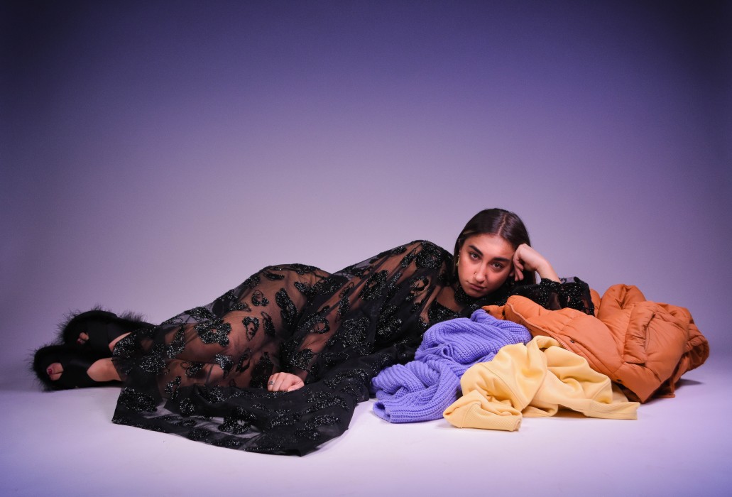 a photo of a woman lying atop a pile of clothes