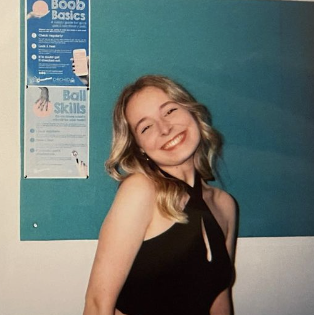 A woman wearing a black shirt in front of a blue background