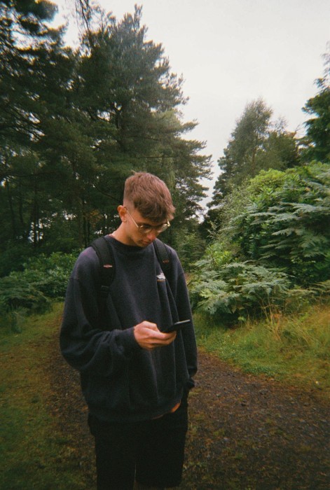 A man holding a phone in a forest